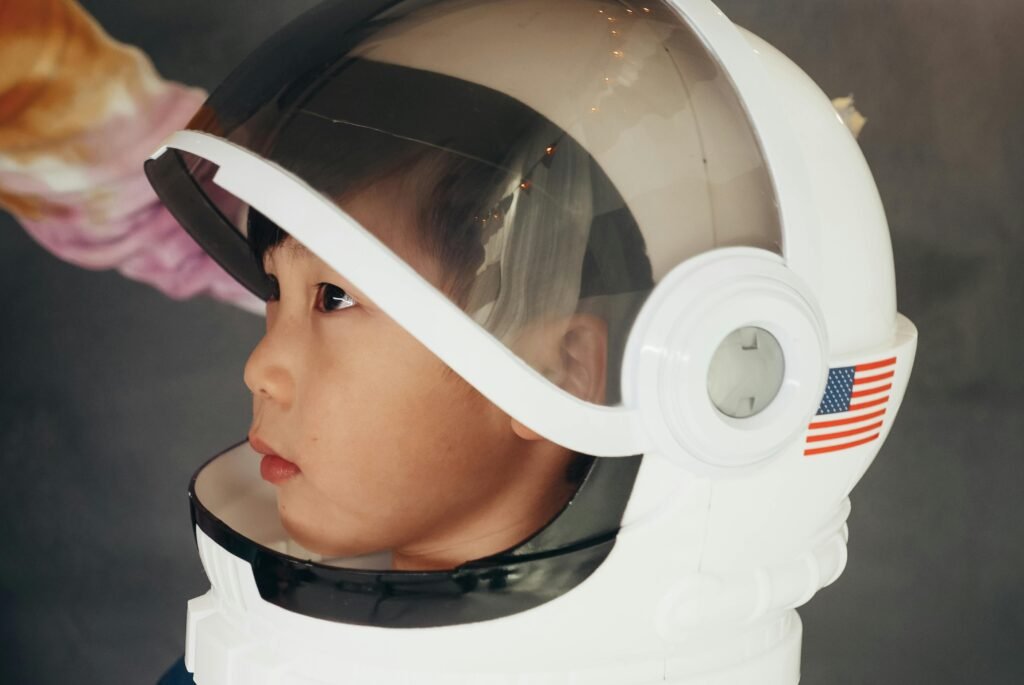 A young child wearing an astronaut helmet looks into the distance, inspiring imagination and adventure.